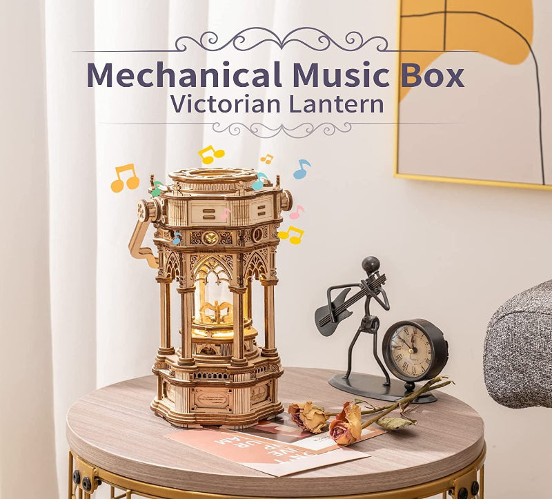 Mechanical music box labeled 'Victorian Lantern' on a table with decorative items.